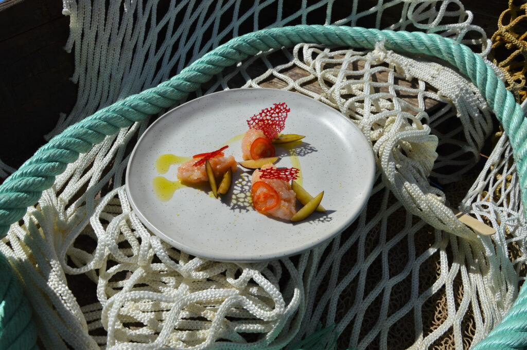 Quenelle di gambero viola aromatizzato con zest di limone servito con prugne, pomodoro e corallo di gambero rosso